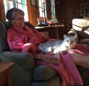 A woman sitting in a chair with her cat.